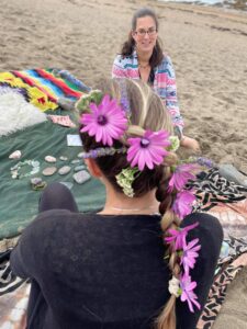 Photo of Jo performing a mother blessing ceremony on the beach