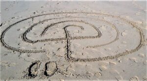 Photo of a simple labyrinth drawn in sand on the beach